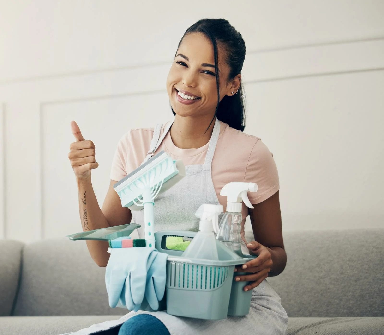 Shot of a woman holding a basket with cleaning supplies at home.